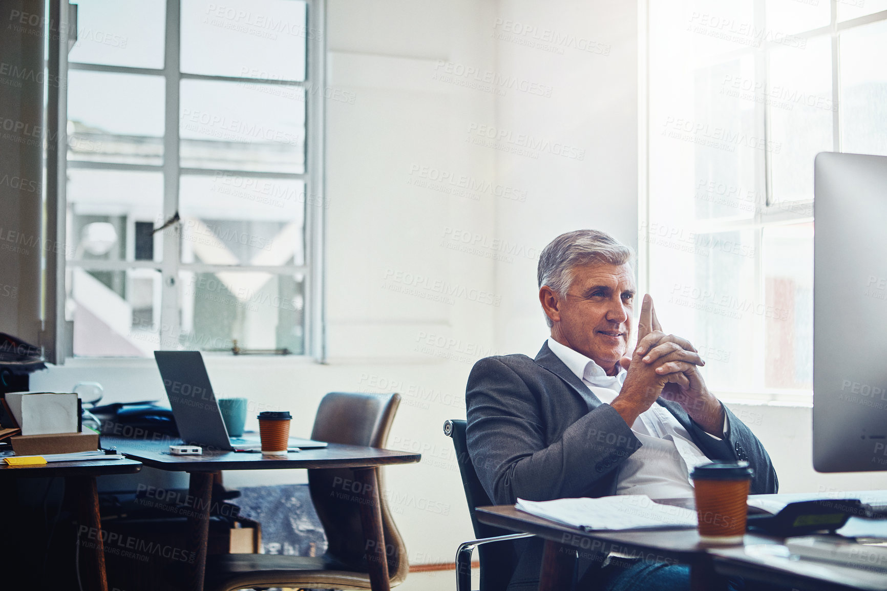 Buy stock photo Shot of a mature businessman working on a computer in an office