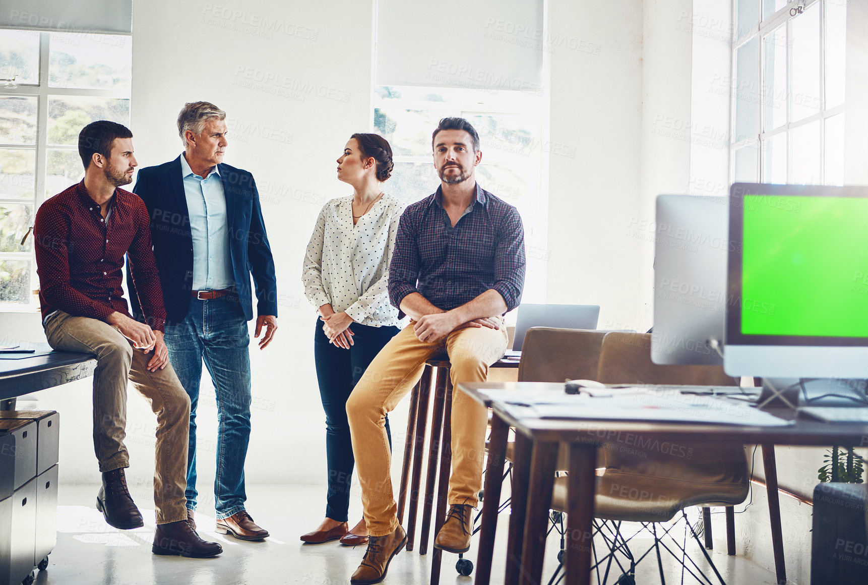 Buy stock photo Portrait of a young man with his colleagues having a discussion in the background