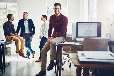 Buy stock photo Portrait of a young man posing while his colleagues stand in the background