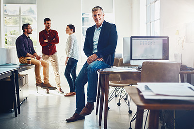Buy stock photo Portrait of a mature man posing while his colleagues stand in the background