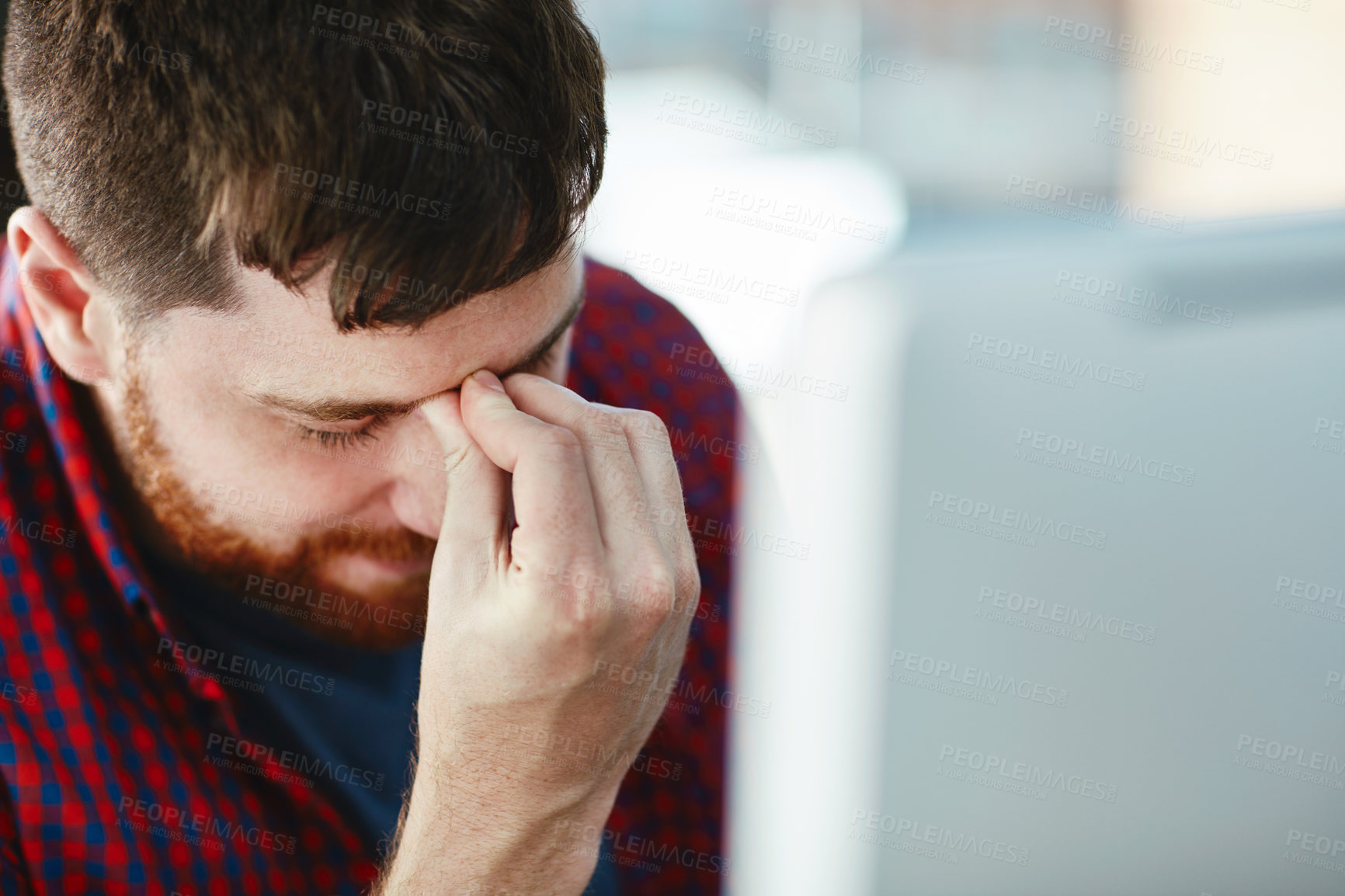 Buy stock photo High angle shot of a young male designer looking stressed in the office