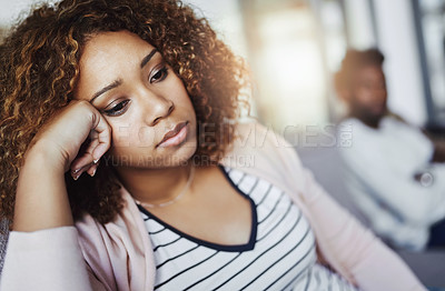 Buy stock photo Shot of a young woman looking despondent after having a fight with her boyfriend at home