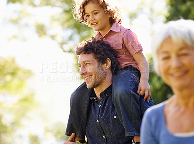 Buy stock photo Shot of a young boy riding on his fathers shoulders
