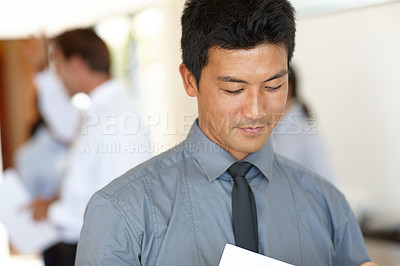 Buy stock photo Asian, businessman and employee with paperwork, documents and workplace. Male professional, staff and reading in corporate, review and development for report, hr and working in company or startup
