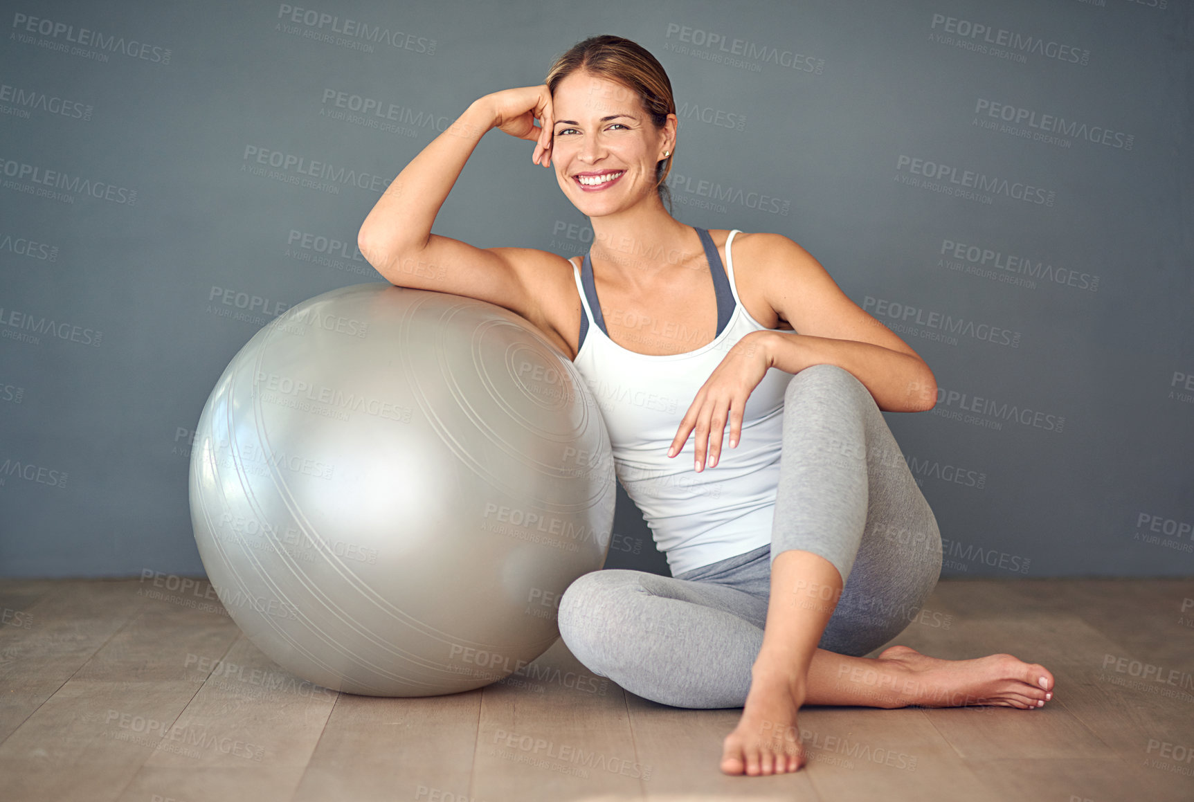 Buy stock photo Shot of a sporty young woman sitting next to her fitness ball