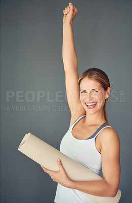 Buy stock photo Happy woman, portrait and yoga mat with fist in celebration for healthy exercise against a grey studio background. Excited female person or yogi with smile for winning, fitness or workout success