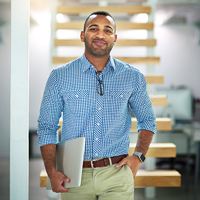 Buy stock photo Cropped portrait of a handsome young businessman carrying his laptop in the office