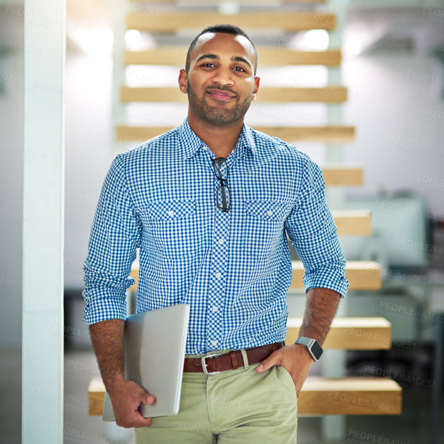 Buy stock photo Cropped portrait of a handsome young businessman carrying his laptop in the office