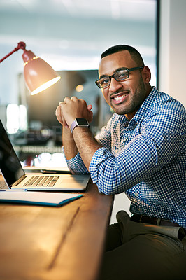 Buy stock photo Portrait of a handsome young businessman working on his laptop in the office