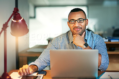 Buy stock photo Portrait of a handsome young businessman working on his laptop in the office