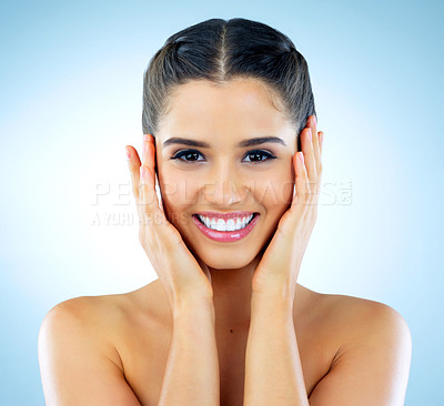 Buy stock photo Studio shot of a beautiful young woman with gorgeous skin posing against a blue background