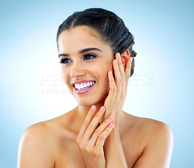 Buy stock photo Studio shot of a beautiful young woman with gorgeous skin posing against a blue background
