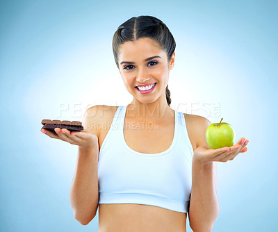 Buy stock photo Studio shot of a woman deciding between healthy and unhealthy foods