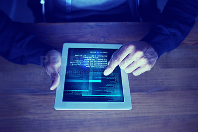 Buy stock photo High angle shot of an unidentifiable computer hacker using a tablet in the dark