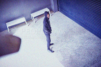 Buy stock photo High angle shot of a sketchy-looking man standing outside a building