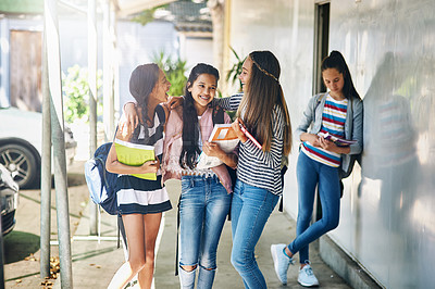 Buy stock photo Shot of a group of schoolgirls chatting in the hallway outside their classroom