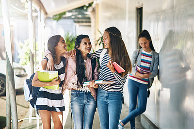 Buy stock photo Shot of a group of schoolgirls chatting in the hallway outside their classroom