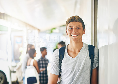 Buy stock photo Portrait of a happy schoolboy standing outside his classroom with classmates in the background