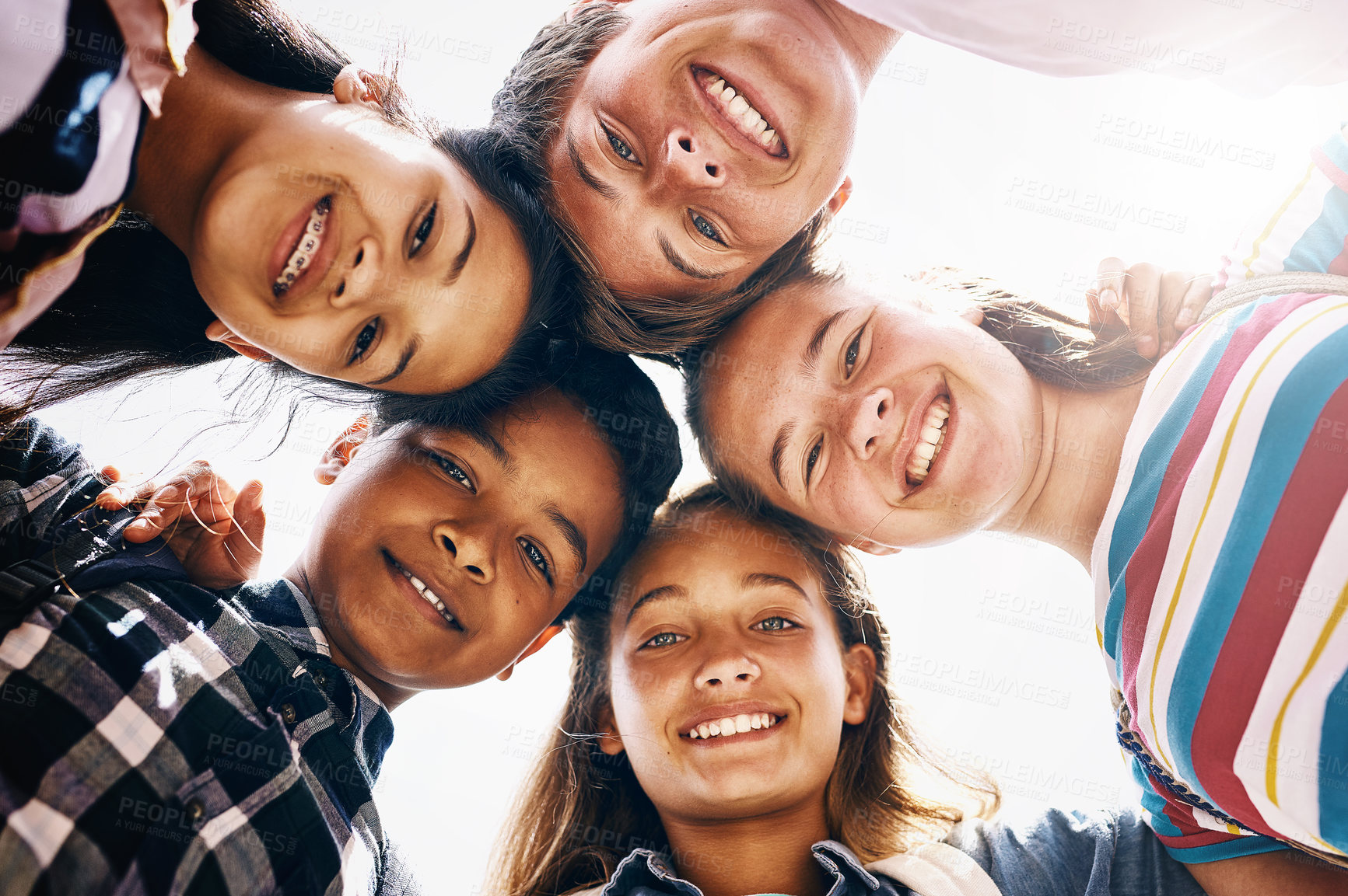 Buy stock photo Huddle, portrait and happy children in school for teamwork, support or development. Low angle, diversity and group of friends with smile in playground for solidarity, education or playing together