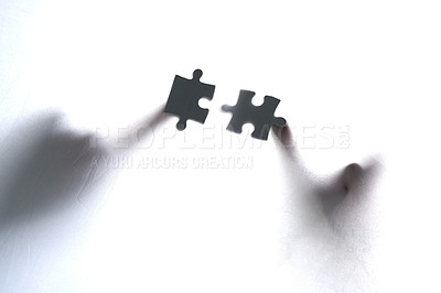 Buy stock photo Cropped shot of two unrecognizable people holding two puzzle pieces together