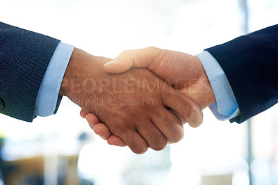 Buy stock photo Cropped shot of two unrecognizable businessmen shaking hands in the office