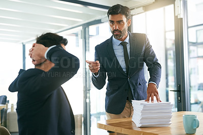 Buy stock photo Shot of a businessman reprimanding one his employees in the office