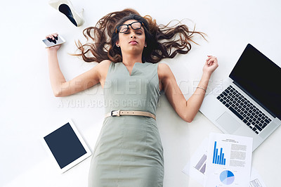 Buy stock photo High angle shot of a young businesswoman lying on her office floor