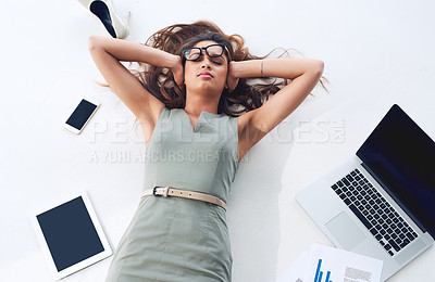 Buy stock photo High angle shot of a young businesswoman lying on her office floor