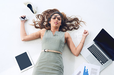 Buy stock photo High angle portrait of a young businesswoman lying on her office floor