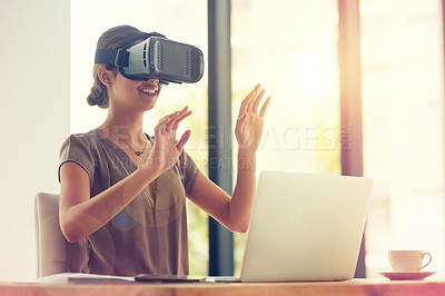 Buy stock photo Shot of a young businesswoman wearing a VR headset while working in an office