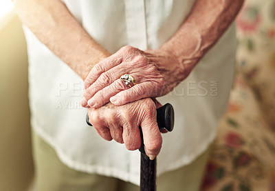 Buy stock photo Hands, walking stick and closeup with senior woman, injury and disabled with balance in retirement in house. Cane, elderly lady and person with disability, support or recovery in home with lens flare