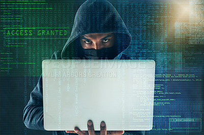 Buy stock photo Portrait of a serious computer hacker using a laptop against a dark background in studio