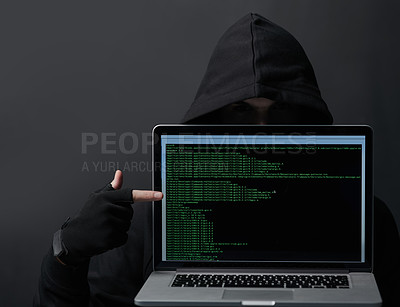 Buy stock photo Shot of an unidentifiable computer hacker holding up a laptop against a dark background