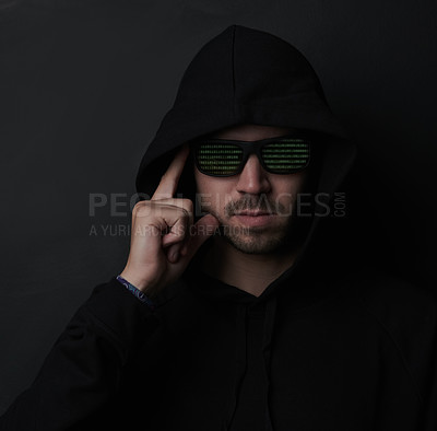 Buy stock photo Shot of an unidentifiable man wearing sunglasses and a hoodie while posing against a dark background