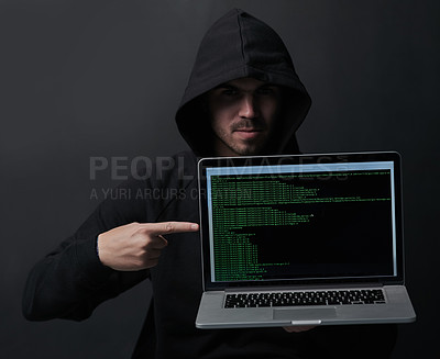 Buy stock photo Portrait of an unidentifiable computer hacker holding up a laptop against a dark background