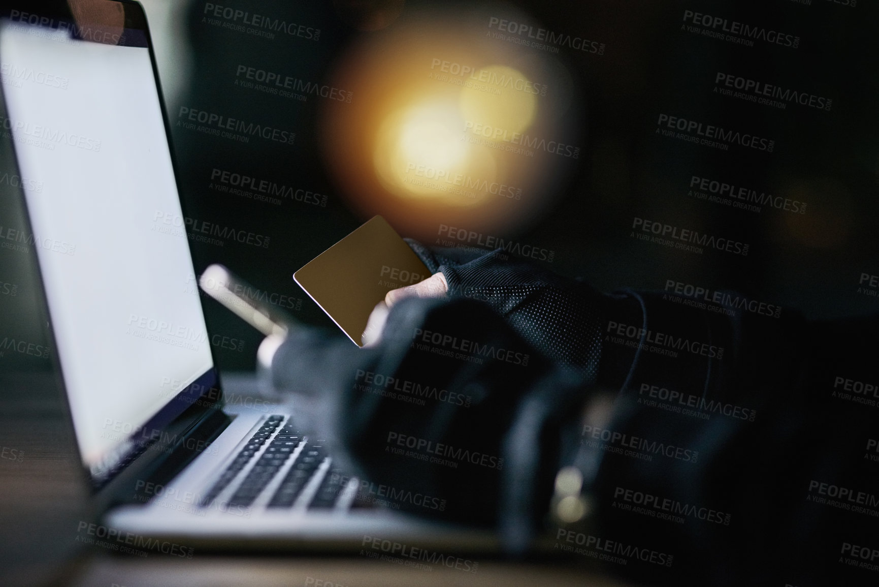 Buy stock photo Shot of an unidentifiable criminal using a laptop to hack into a credit account