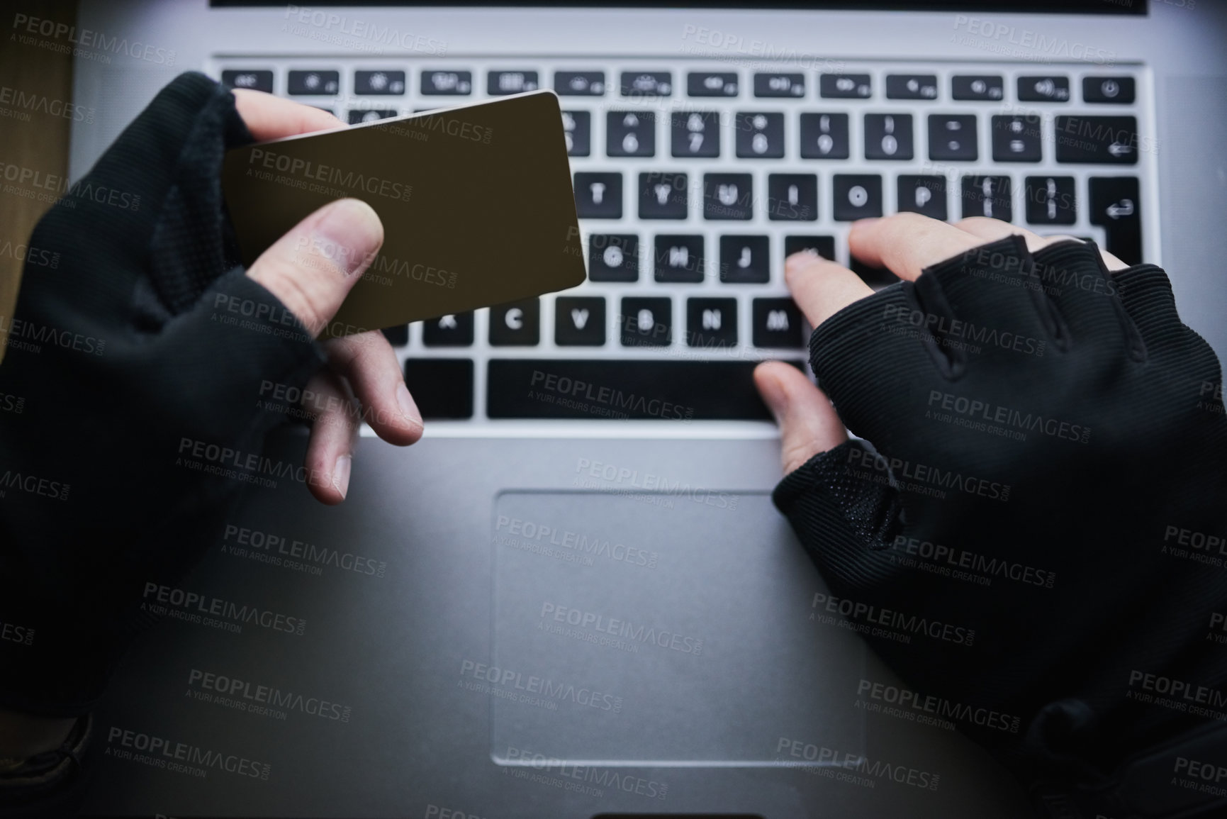 Buy stock photo Shot of an unidentifiable criminal using a laptop to hack into a credit account