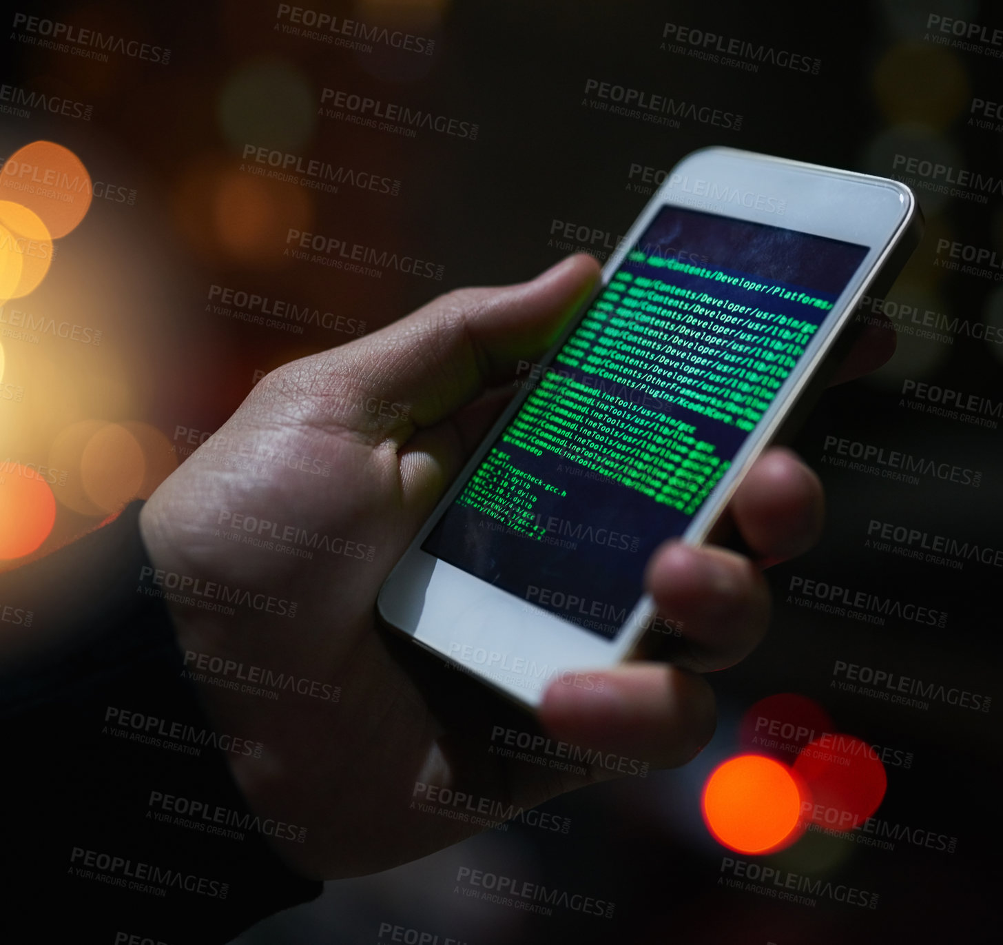 Buy stock photo Shot of an unidentifiable computer hacker using a smartphone to hack into a network