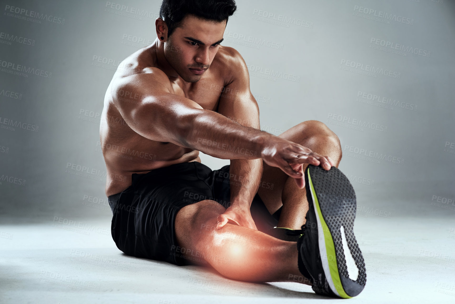 Buy stock photo Stretching, fitness and man with pain in studio, physio and cramp in legs at gym workout for body builder training. Exercise, glow and overlay with muscle, injury and ache on grey background