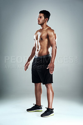 Buy stock photo Full length shot of a sporty young man standing against a grey background