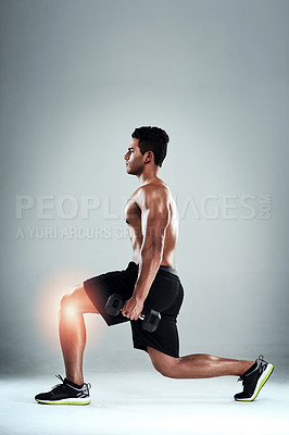 Buy stock photo Studio shot of a sporty young man working out with an injured knee against a grey background
