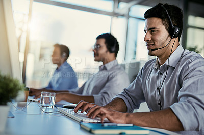 Buy stock photo Crm agent, smile and man in coworking space consulting with advice and happiness at help desk. Happy phone call, conversation and customer support consultant speaking on headset in callcenter office.