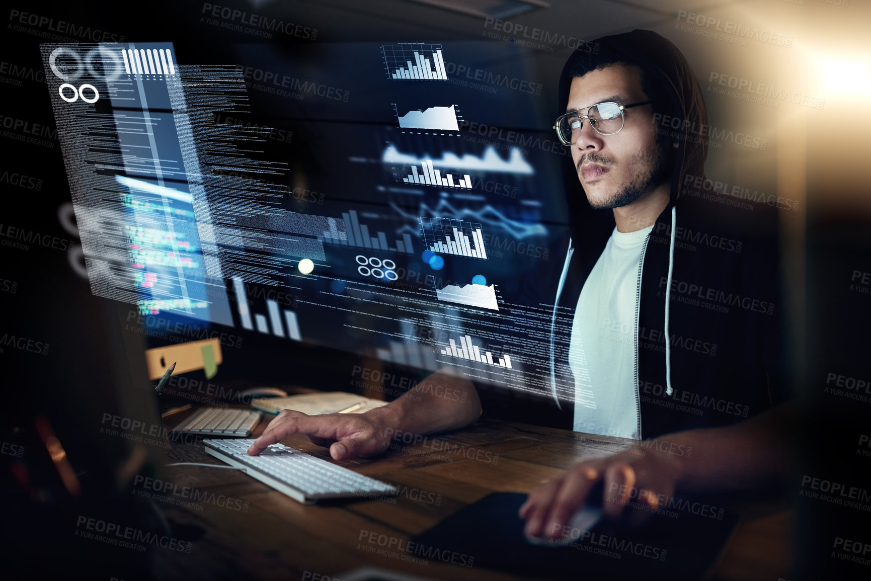 Buy stock photo Shot of a young hacker cracking a computer code in the dark