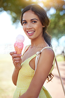 Buy stock photo Portrait of an attractive young woman enjoying an ice cream in the park