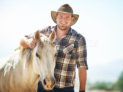 Buy stock photo Shot of a farmer standing with his horse