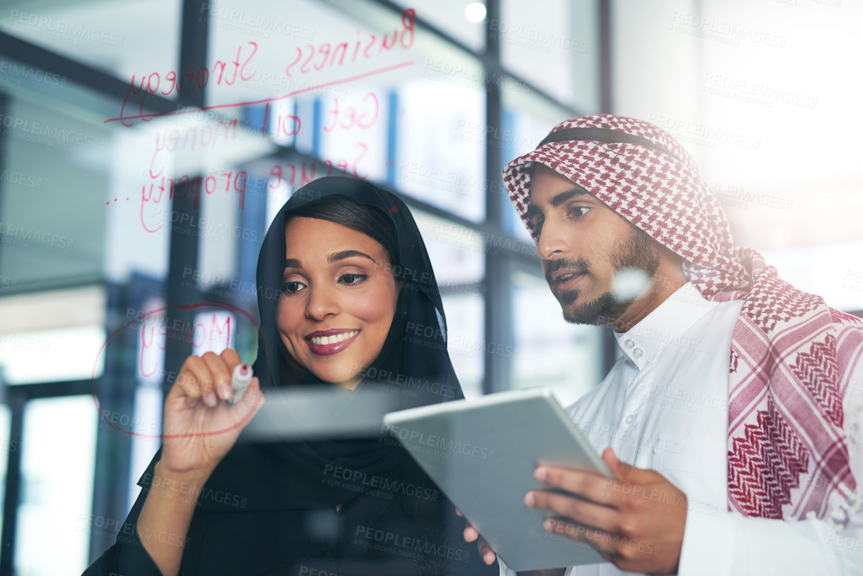 Buy stock photo Shot of two muslim colleagues having a brainstorming session at work in a modern office