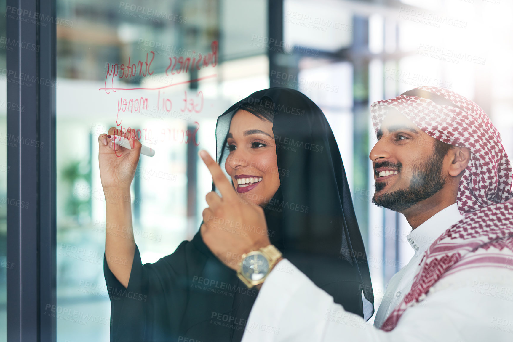 Buy stock photo Shot of two muslim colleagues having a brainstorming session at work in a modern office
