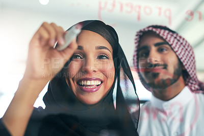 Buy stock photo Shot of two muslim colleagues having a brainstorming session at work in a modern office