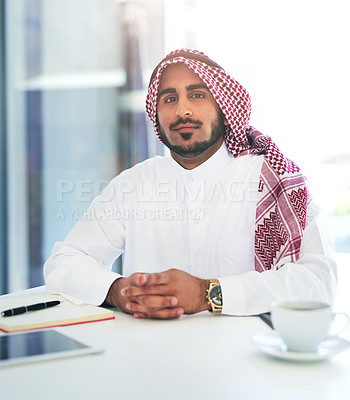 Buy stock photo Portrait of a confident young muslim businessman working at his desk in a modern office