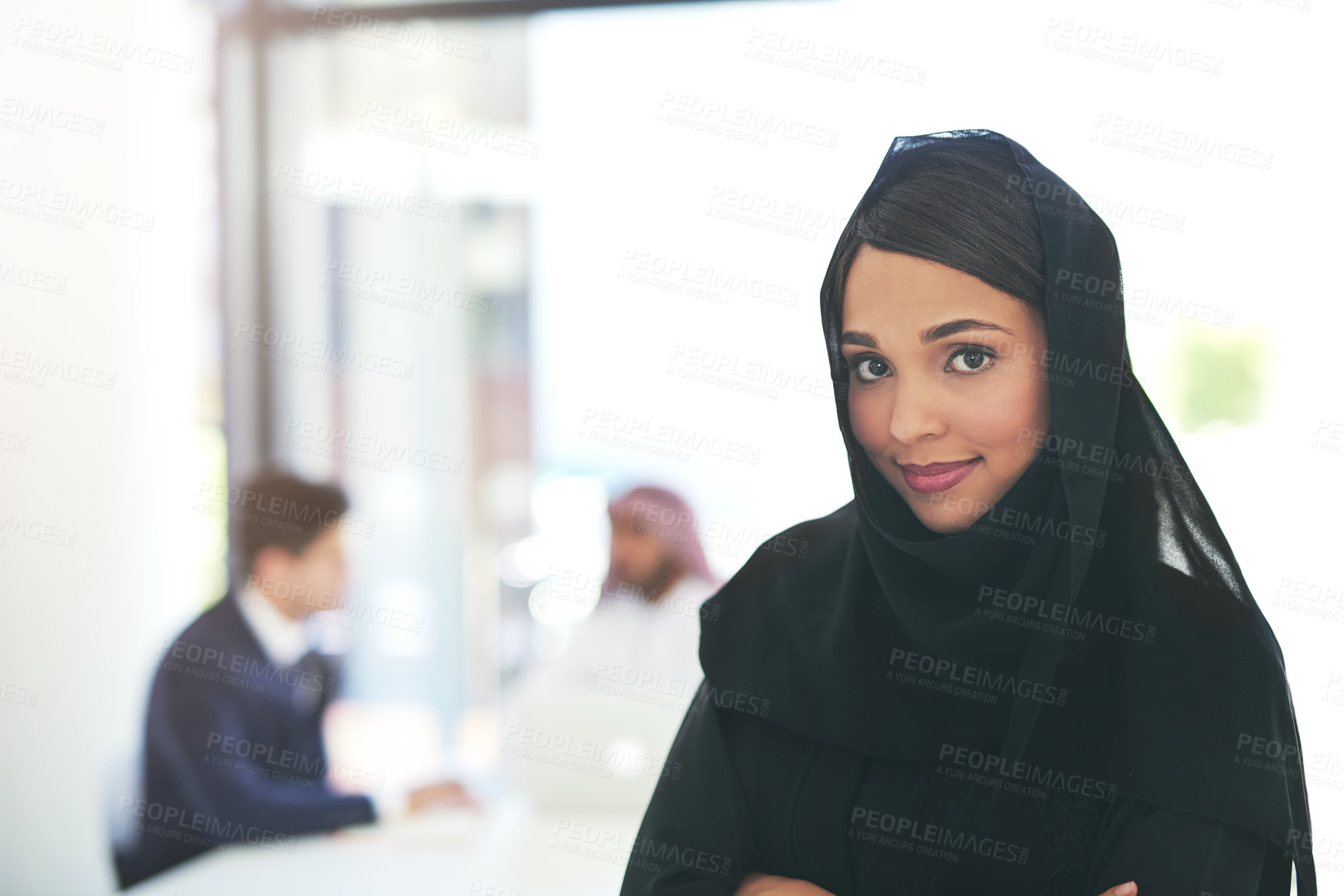 Buy stock photo Portrait of a confident young muslim businesswoman working in a modern office with her colleagues in the background